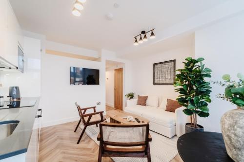 a living room with a white couch and a table at Royal House Stylish Apartments - Chester in Chester