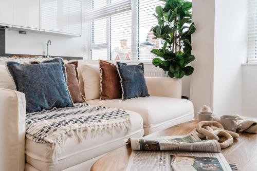 a living room with a white couch and blue pillows at Royal House Stylish Apartments - Chester in Chester