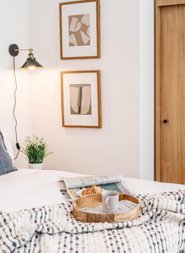 a bed with a basket with a coffee mug on it at Royal House Stylish Apartments - Chester in Chester