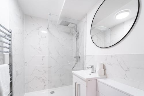 a white bathroom with a sink and a mirror at Royal House Stylish Apartments - Chester in Chester