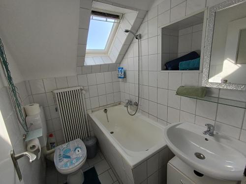 a bathroom with a sink and a tub and a toilet at Ferienwohnung kleine Möwe mit E-Bike Verleih in Wilhelmshaven
