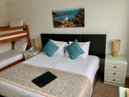 a hotel room with two beds and two night stands at La Collinette Hotel, Cottages & Apartments in St Peter Port