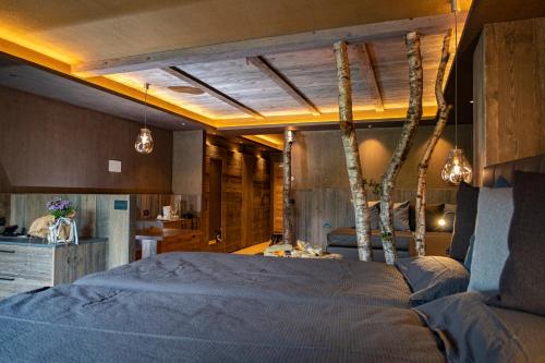 a bedroom with a large bed with trees on it at La Roccia Wellness Hotel in Cavalese