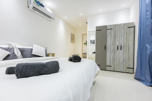 a white bedroom with a large white bed and a door at My Way in Ras al Khaimah