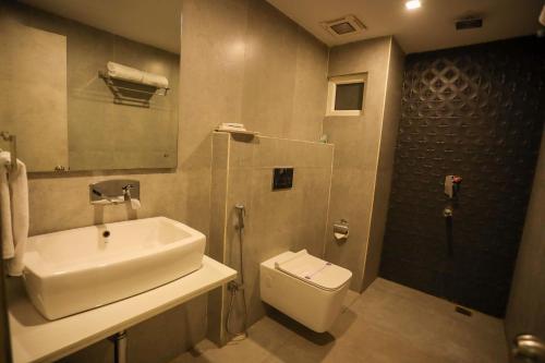 y baño con lavabo, aseo y ducha. en Hotel Coal Capital, en Dhanbād