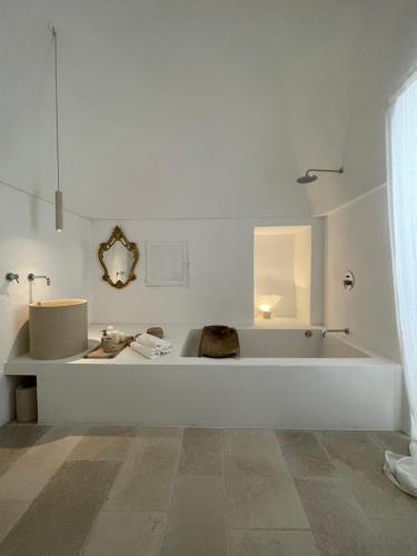 um banheiro branco com banheira e pia em I Tre Coni by Acqua di Puglia em Locorotondo