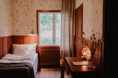 - une chambre avec un lit, une fenêtre et une table dans l'établissement Stiftsgården Tallnäs, à Skillingaryd