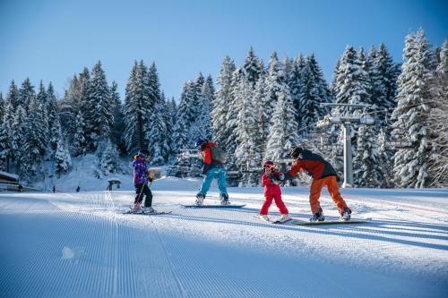 a group of people on skis in the snow at Hotel Arcobaleno in Fai della Paganella