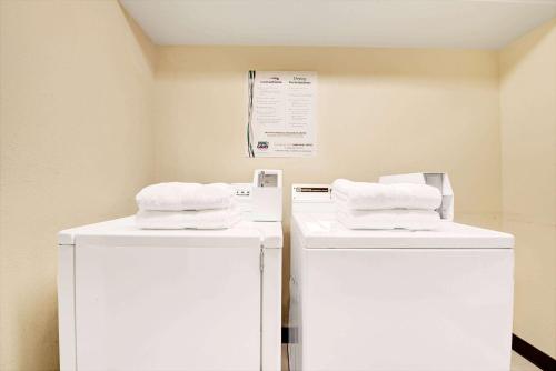 two white refrigerators sitting next to each other in a room at Days Inn by Wyndham Dallas Plano in Plano