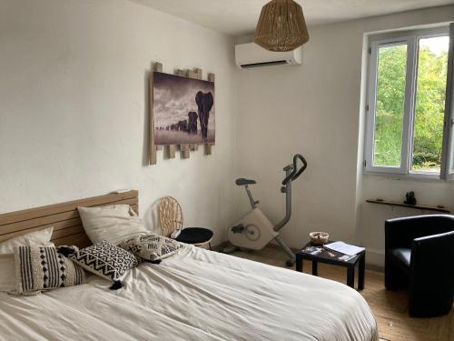 une chambre avec un lit, un bureau et une lampe dans l'établissement chambre privée dans maison drômoise - viarhona - autoroute - jacuzzi à réserver en supplément, à Châteauneuf-du-Rhône