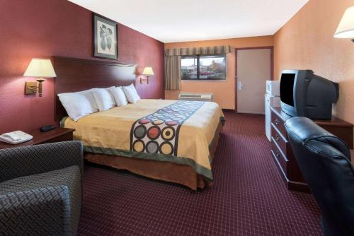 a hotel room with a bed and a tv at Super 8 by Wyndham Strongsville/Cleveland in Strongsville