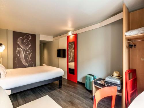 Habitación de hotel con cama y escritorio en ibis Bourges Centre en Bourges