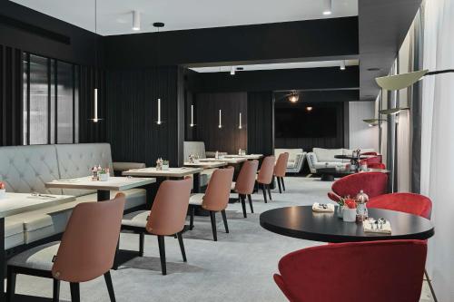 a dining room with tables and red chairs at Radisson Collection Hotel, Warsaw in Warsaw