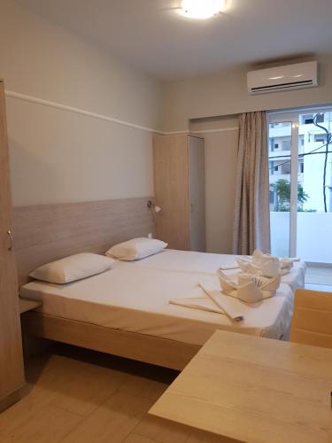 a bedroom with two beds and a window at Poppy Beloni in Chania Town