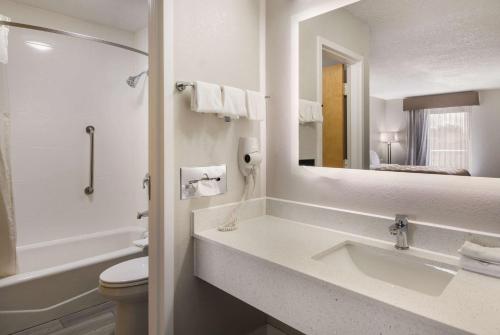 een badkamer met een wastafel, een toilet en een spiegel bij Quality Inn in Emporia