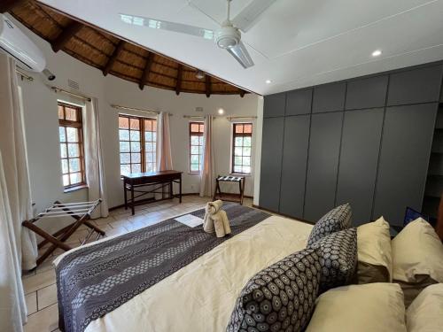 a teddy bear sitting on a large bed in a bedroom at MILIMA Big 5 Safari Lodge in Hoedspruit