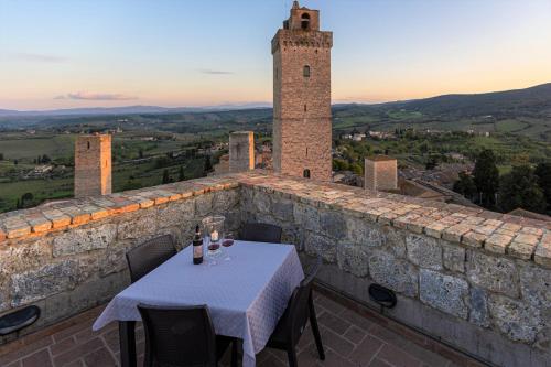 a table with wine glasses on top of a stone building at Torre Salvucci Maggiore Medieval Tower Experience in San Gimignano