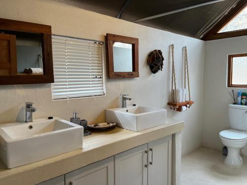 a bathroom with two sinks and a toilet at MILIMA Big 5 Safari Lodge in Hoedspruit