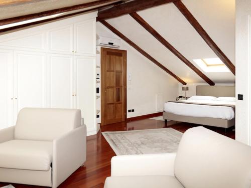 ein Wohnzimmer mit 2 Betten und einem Sofa in der Unterkunft Relais Juliette in La Morra