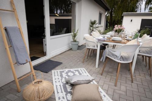 un patio con tavolo, sedie, tavolo e tavolo di 5 Sterne Premium Ferienwohnung in Ostseenähe a Loose
