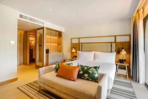 a bedroom with a large bed and a couch at Holiday Inn Resort Samui Bophut Beach by IHG in Bophut 