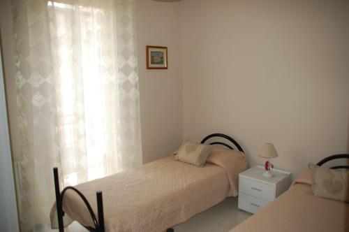 a small bedroom with two beds and a window at Appartamento "Rina Centro Sicilia" in Pietraperzia