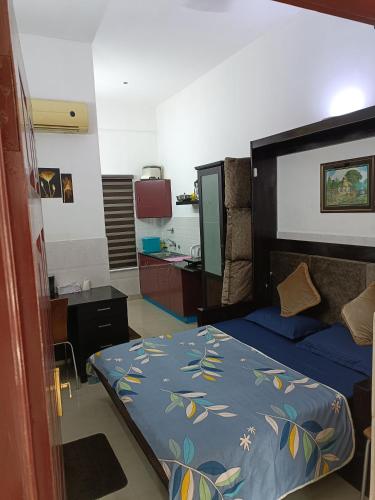 a bedroom with a bed with a blue comforter at Safa Serviced Apartments in Cochin