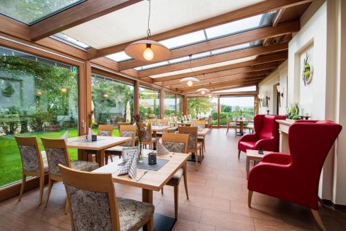 a restaurant with tables and chairs and windows at Landhotel Seerose in Langenzenn