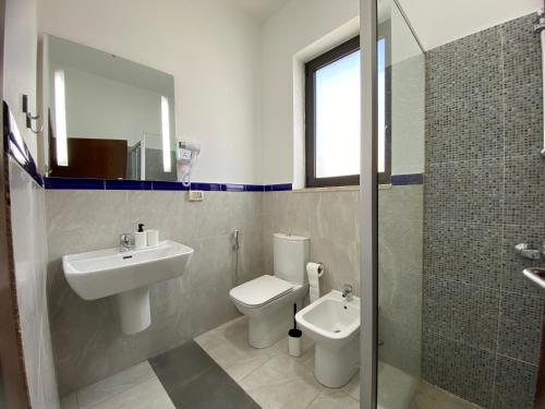 a bathroom with a sink and a toilet and a shower at Lemon Tree Residence in Amman