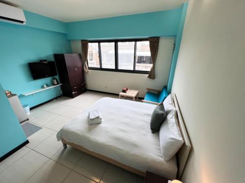 a bedroom with a bed in a room with blue walls at 一中小窩馨 in Taichung