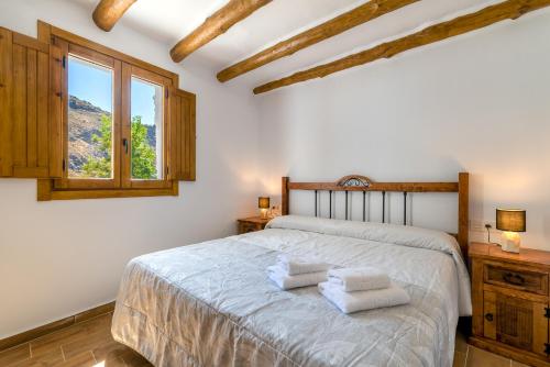 1 dormitorio con 1 cama con 2 toallas en La Alquería- Pampaneira, en Pampaneira