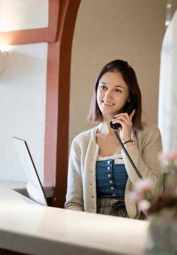 a woman talking on a cell phone in front of a desk at Hotel am Mirabellplatz in Salzburg