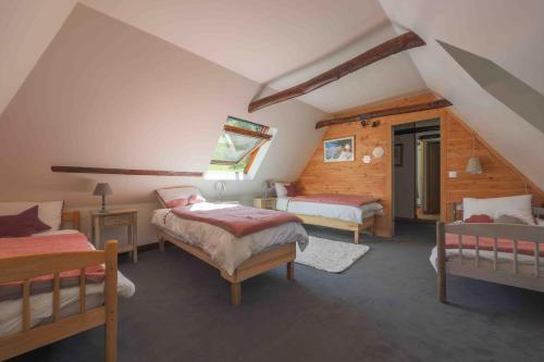 a bedroom with two beds in a attic at Le Domaine de Castille - maison pyrénéenne de charme - spa de nage in Arrens-Marsous