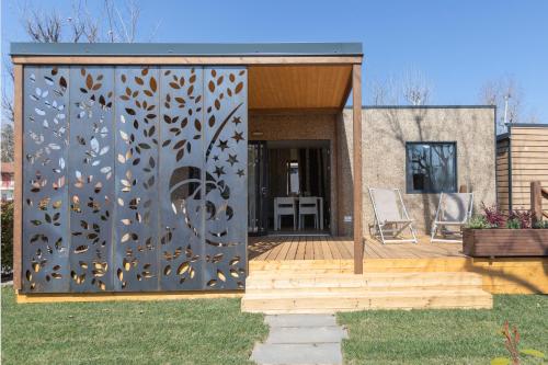 a house with a metal screen in the yard at Camping Village Lago Maggiore in Dormelletto