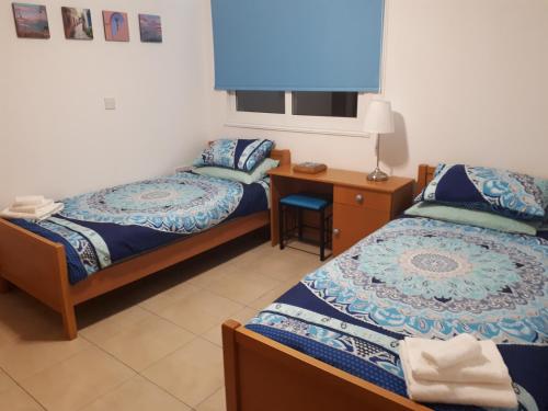 two beds in a room with a desk and a bed sidx sidx sidx at Stunning Spacious 2-Bed Apartment in Liopetri in Liopetri