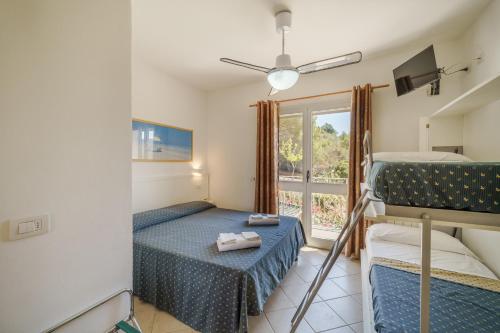 a bedroom with two bunk beds and a window at Hotel Villa Wanda in Porto Azzurro