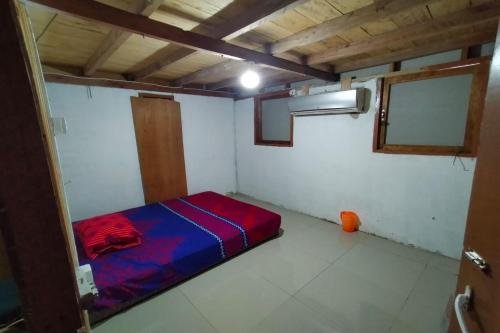 a small room with a red and blue bed in it at EXPRESS O 91702 Mandeh Homestay Syariah in Painan