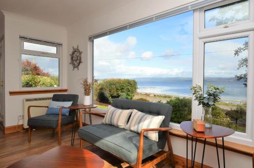 sala de estar con 2 sillas y ventana grande en Bay View, en Lochgilphead