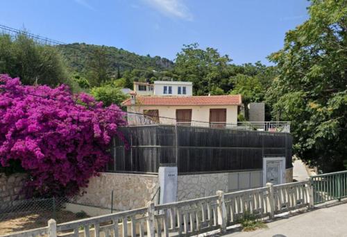 una casa con una valla y flores púrpuras en EDEN CAP : A delightful villa lodges 11 adults just one km away from Monte Carlo station en Beausoleil