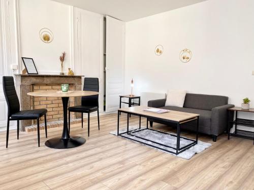 een woonkamer met een bank en een tafel bij * Le Droma D’or * Appartement Confort * Centre-ville in Calais
