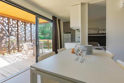 a kitchen with a table with wine glasses on it at Camping Village Lago Maggiore in Dormelletto
