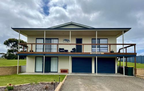 a house with blue doors and a balcony at Yorks View in Kingscote