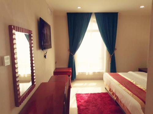 a bedroom with a bed and a mirror and a window at Villa Park in Al Khobar