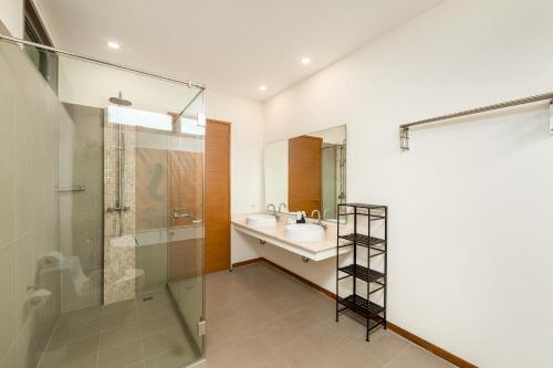 uma casa de banho com uma cabina de duche em vidro e um lavatório. em Ka Villas x GSG em Phuket