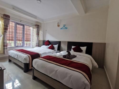 a bedroom with two beds with a teddy bear on them at Om Bramha Hotel in Kathmandu