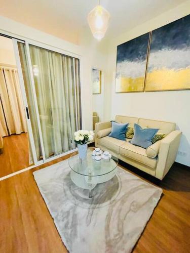 a living room with a couch and a coffee table at Stylish 1 bedroom condo with pool view and Fast WIFI in Manila