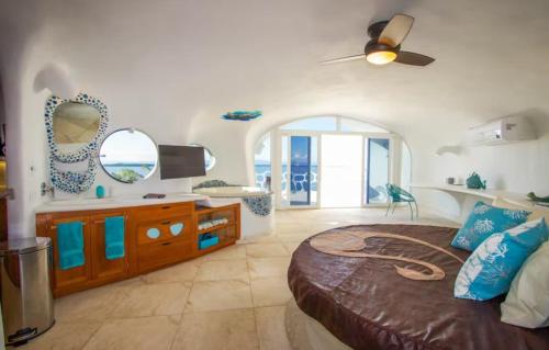 a bedroom with a large bed with blue pillows at Alterhome Swan villas with swimming pool and ocean views in Placencia Village