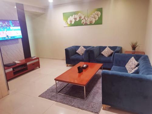 a living room with a blue couch and a table at Villa Park in Al Khobar