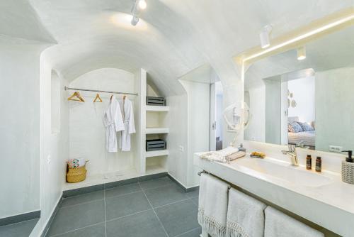 a white bathroom with a sink and a mirror at Casa Vicenza - Private house with Jacuzzi and Aegean View in Foinikiá