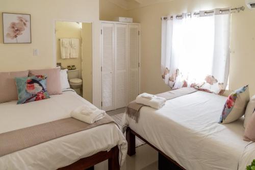 a bedroom with two twin beds and a window at Villa Maison de Soleil in Florence Hall